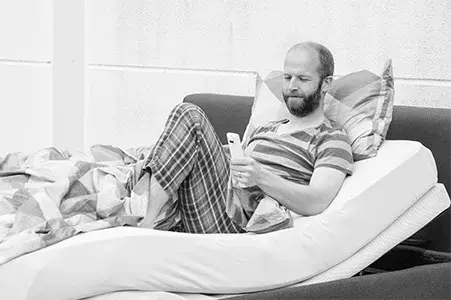 Unser Produktmanager Ansar liegt entspannt im Bett und liest.